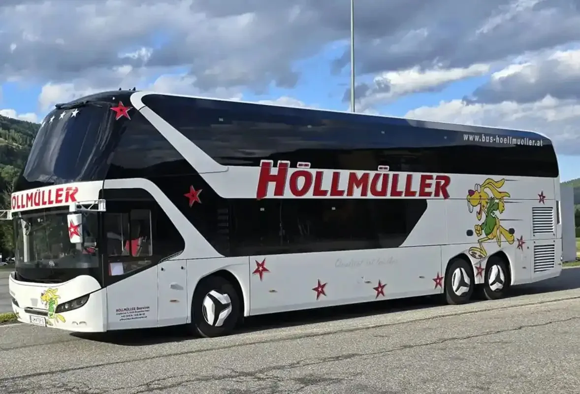 Neoplan-Skyliner-Doppeldecker von Höllmüller mit rotem Schriftzug auf einem Parkplatz