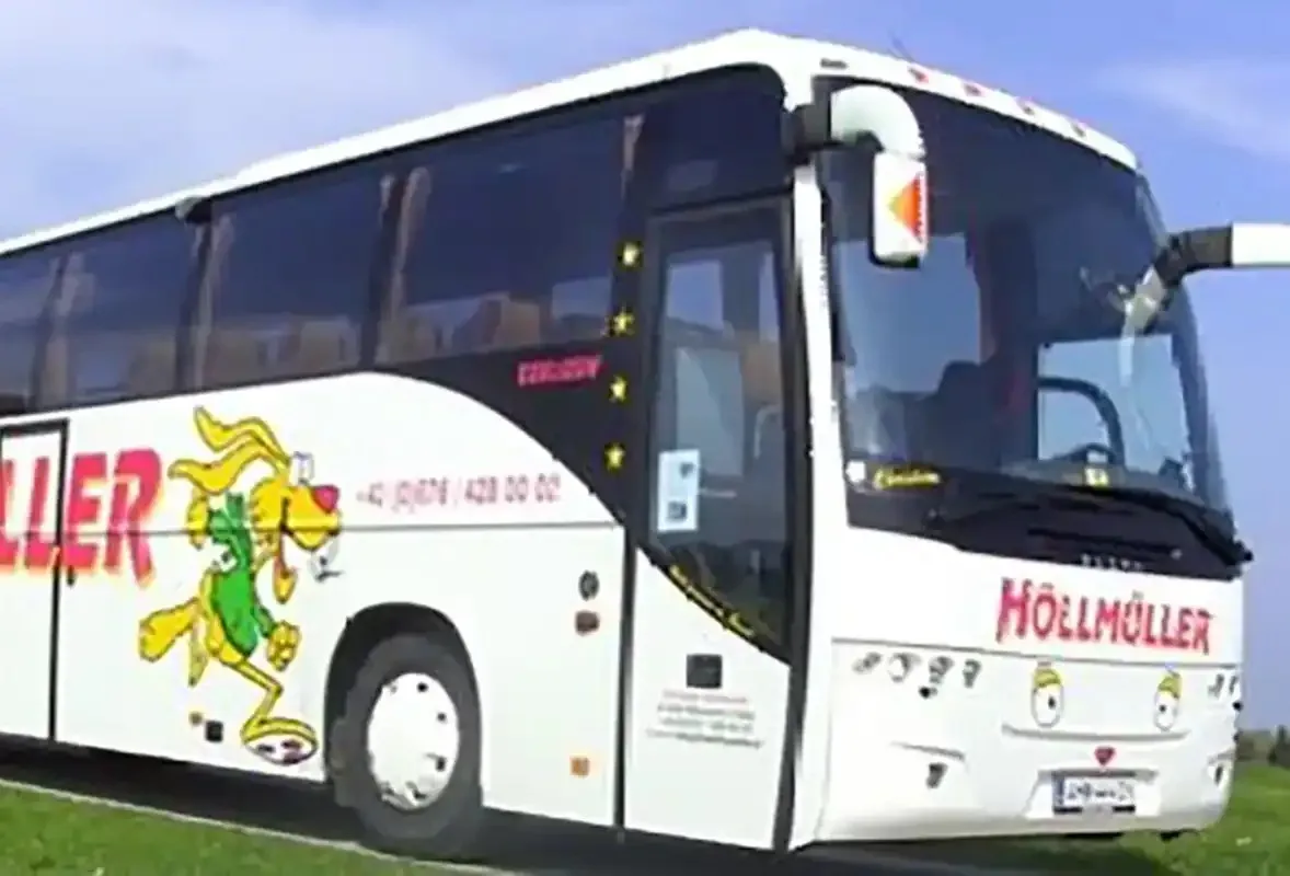 Weißer Höllmüller-Reisebus mit Hase und rotem Schriftzug, schräg von vorne